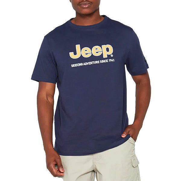 A man wearing a navy blue JEEP logo applique tee with short sleeves and a crew neck.