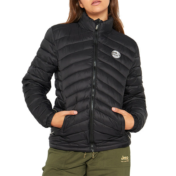 A woman wearing a black Jeep Ladies Core Puff Jacket with a visible brand logo on the chest.