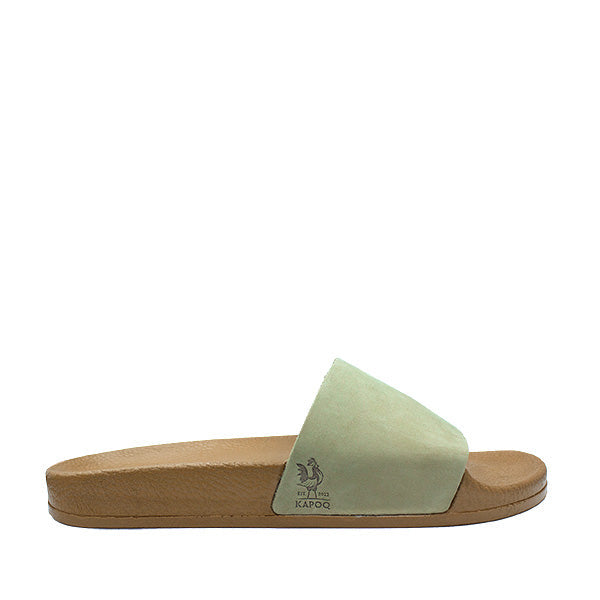 Mint green slide sandal with cork sole on a white background, featuring a brand logo.