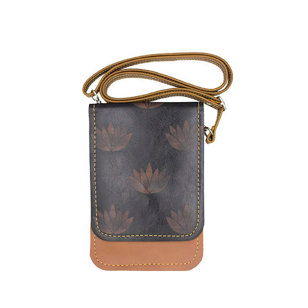 A tan and black leather shoulder bag with floral abstract lotus prints and a sturdy brown strap.