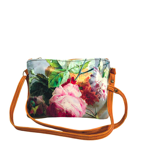 A large shoulder bag with a pink rose floral pattern and a tan leather strap.