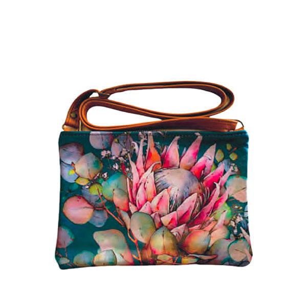 A multicolored floral-patterned leather shoulder bag with a brown strap.