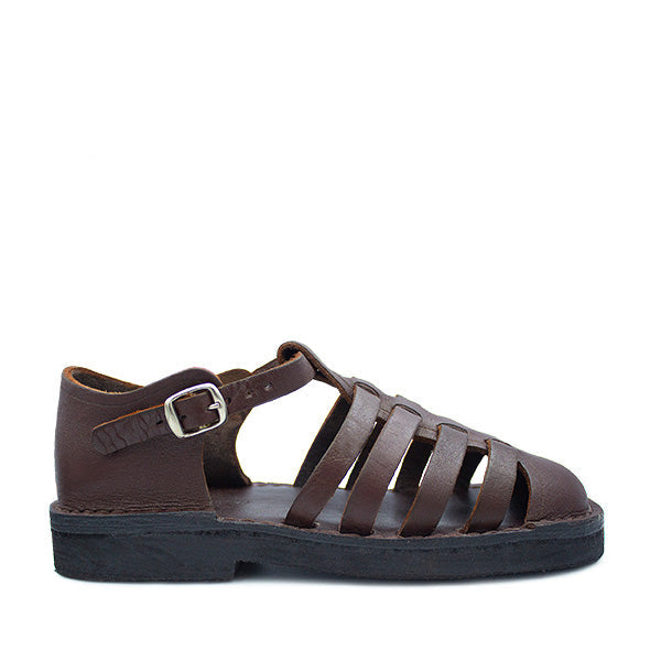 A brown leather sandal with a buckle strap and a flat sole, displayed against a white background.