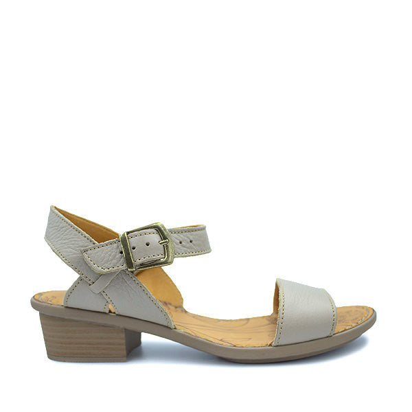 A stone beige ladies' leather sandal with an adjustable strap and buckle closure, featuring a medium heel.