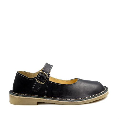 A black handcrafted leather shoe with a buckle strap and visible stitching on the sole.