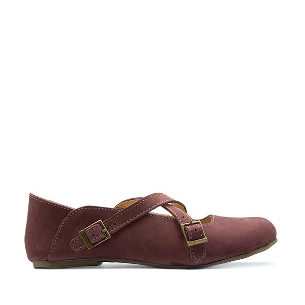 A purple nubuck leather flat shoe with buckle closures, handcrafted with a logo on the heel.