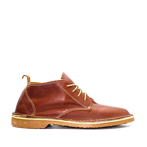 A traditional South African Oukraal vellie shoe in Tan Rust color, featuring a lace-up closure and a thick sole.