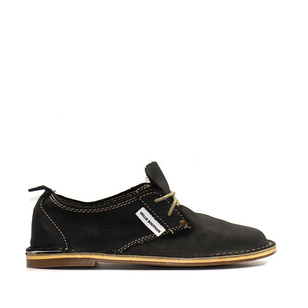 A single black vellie shoe for women with a lace-up closure.