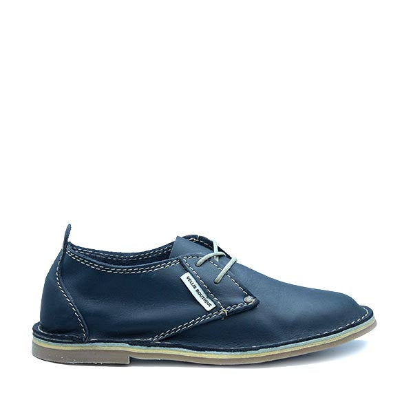 A navy-colored, low-top leather vellie with a lace-up closure and a flat sole.