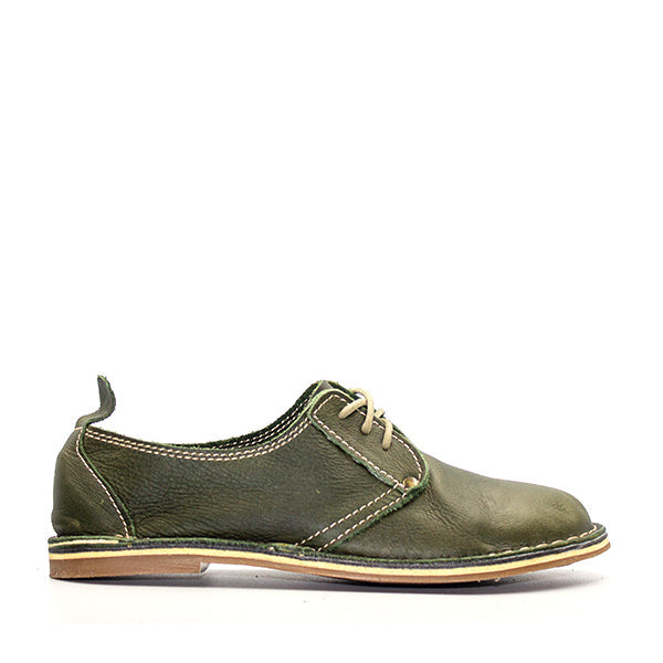 A green, handcrafted leather shoe with a slight heel lift and lace-up closure, made in South Africa.